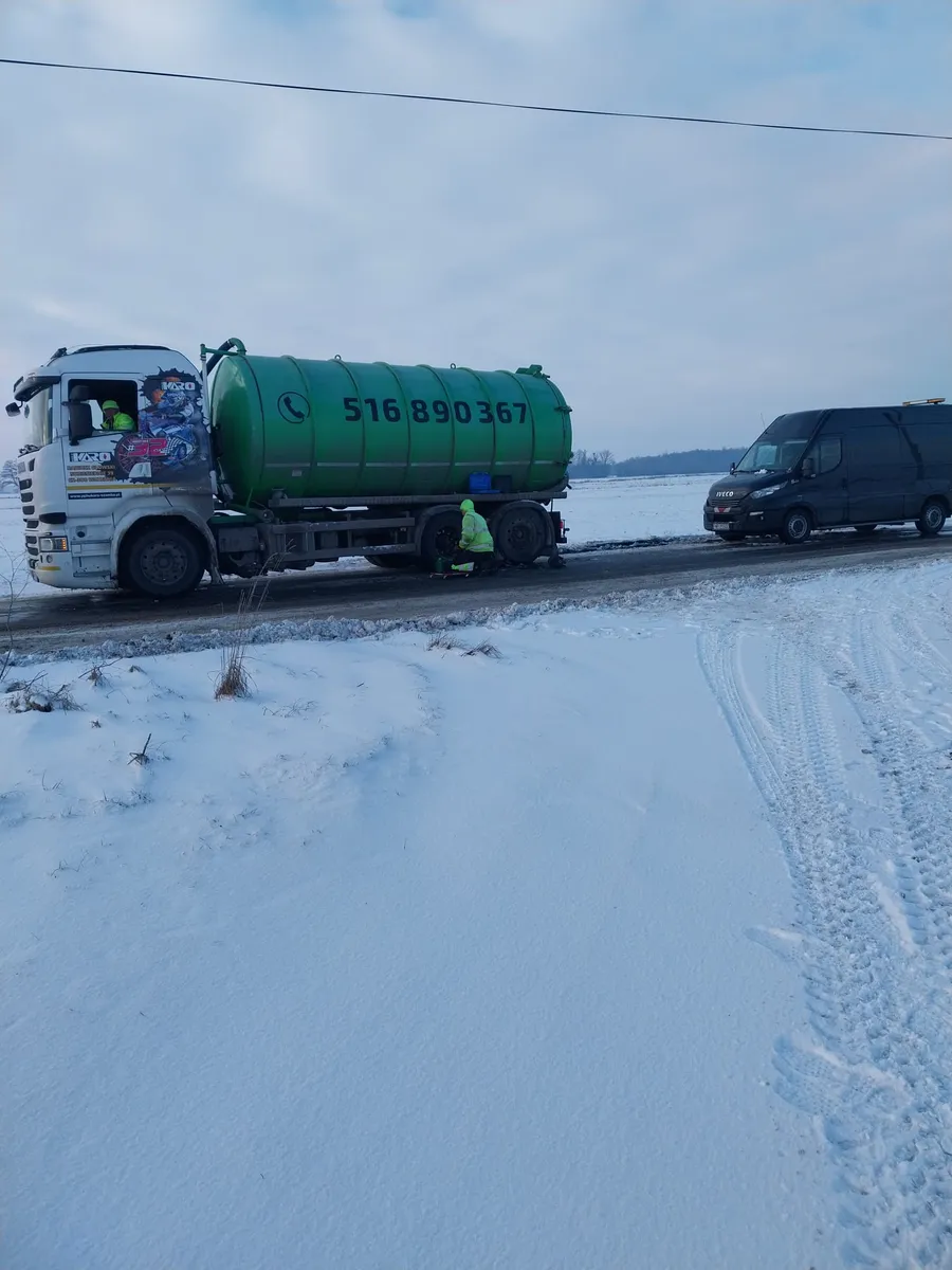 Mechanik podłączający kable rozruchowe do akumulatora samochodu